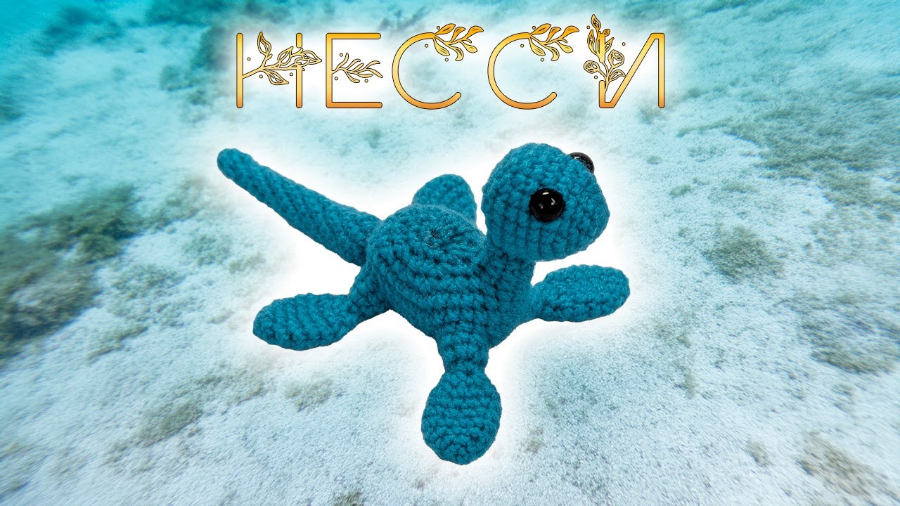 Вязаный игрушечный дельфин, выполненный крючком, на фоне морской волны.