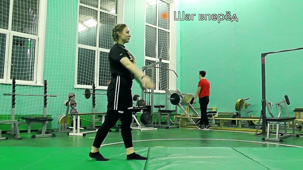 Ученик выполняет упражнение на гимнастике в спортивном зале с оборудованием.