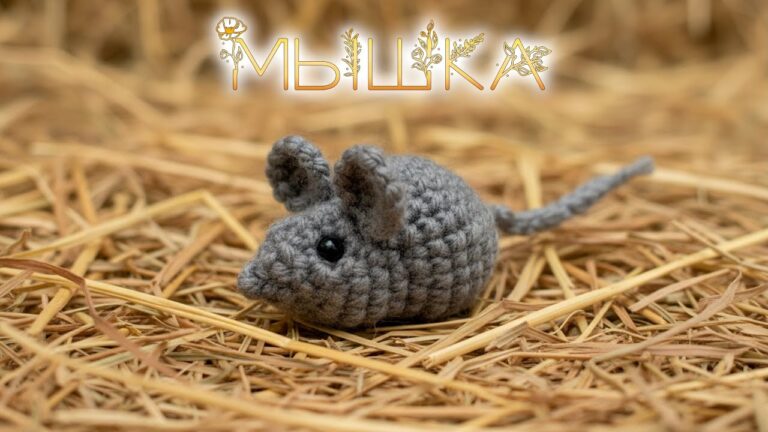Вязаная мягкая игрушка-мышка, сделанная крючком, на фоне сена.