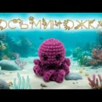 Вязаная игрушка-осьминожка в аквариуме с коралловыми рифами.